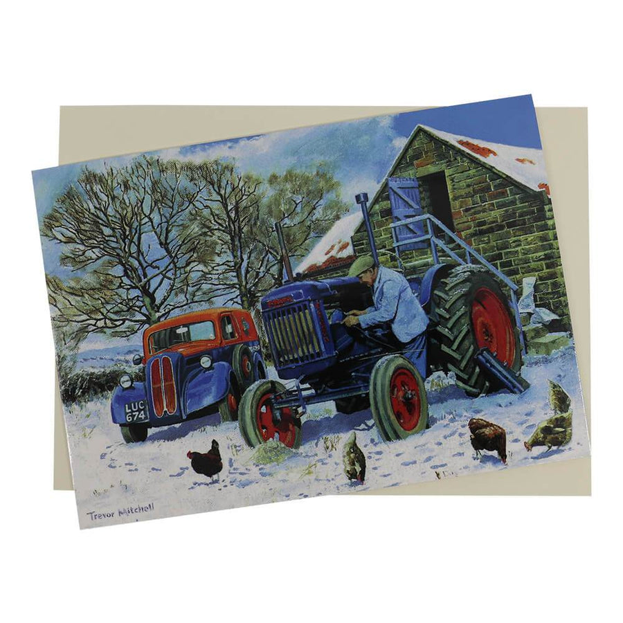 Fordson tractor Christmas card features a blue Major tractor in a snow-covered farmyard next to a roadside assistance van and getting some help on starting the engine.