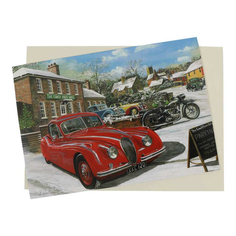 Jaguar Christmas card features a red Jaguar XK120 classic car in a snow-covered street scene with other vintage cars and motorcycle in the background.