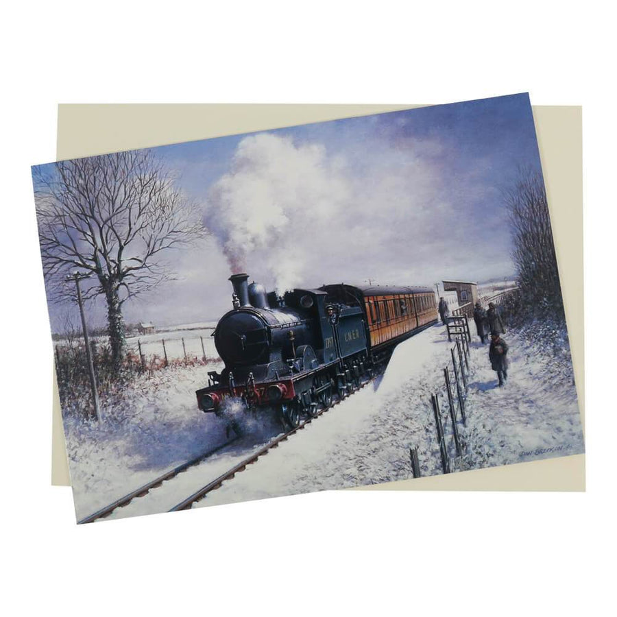 This period Steam train Locomotive Christmas card features a vintage steam train pulling away from a small rural station surrounded by snow-covered fields.